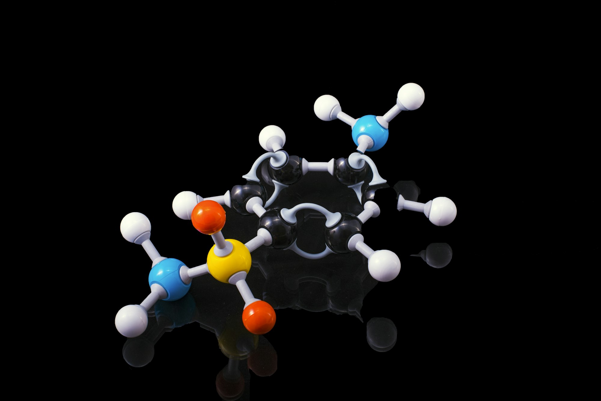 Ball-and-stick model of a molecule against a black background